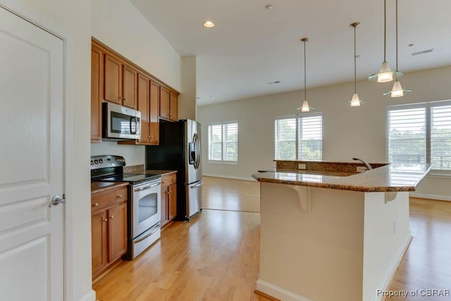 670 Town Center Dr Unit 418, Newport News, VA 23606 - kitchen featuring stainless steel appliances, light wood-style floors, brown cabinetry, and recessed lighting