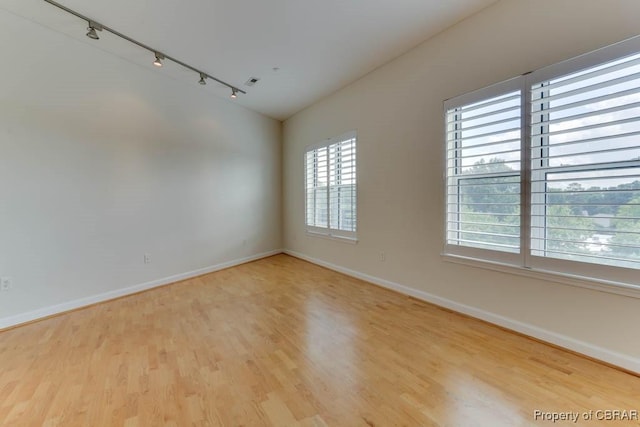 670 Town Center Dr Unit 418, Newport News, VA 23606 - spare room featuring track lighting, baseboards, wood finished floors, and vaulted ceiling