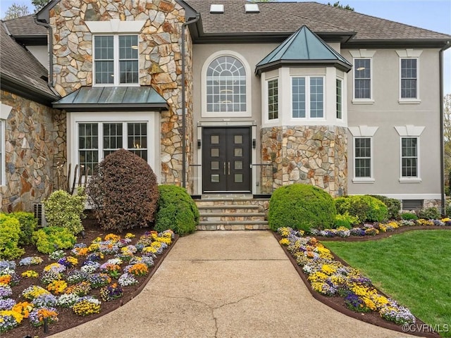 11507 Barrington Bridge Ter, Henrico, VA 23233 - doorway to property with stone siding, stucco siding, roof with shingles, a standing seam roof, and a lawn