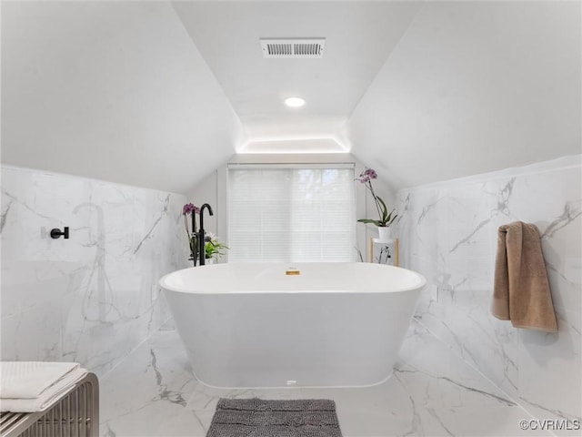 11507 Barrington Bridge Ter, Henrico, VA 23233 - bathroom featuring tile walls, marble tiled floors, a freestanding tub, and lofted ceiling