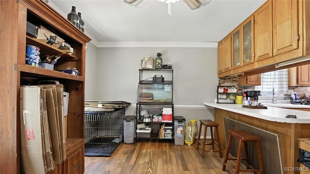 3913 Terjo Ln, Chester, VA 23831 - kitchen featuring crown molding, wood finished floors, ceiling fan, glass insert cabinets, and light countertops