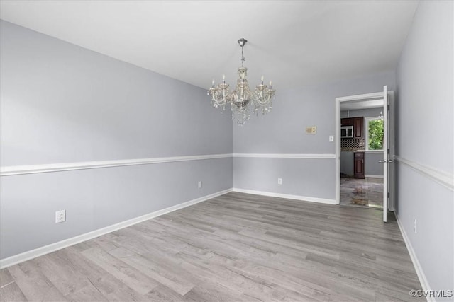807 N Ave, Hopewell, VA 23860 - empty room featuring a chandelier, wood finished floors, and baseboards