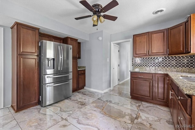 807 N Ave, Hopewell, VA 23860 - kitchen featuring stainless steel refrigerator with ice dispenser, light marble finish floors, light stone counters, tasteful backsplash, and a textured ceiling