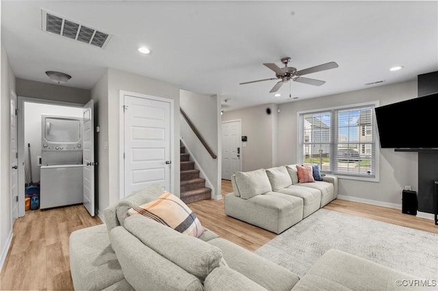 3821 Meridian Ave, Richmond, VA 23234 - living room featuring stacked washer and clothes dryer, stairs, light wood-type flooring, and recessed lighting