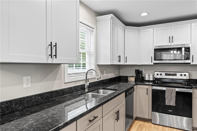 3821 Meridian Ave, Richmond, VA 23234 - kitchen with appliances with stainless steel finishes, a sink, white cabinets, dark stone countertops, and recessed lighting