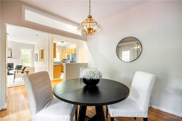 14000 Shady Pointe Ct, Midlothian, VA 23112 - dining space with a chandelier, light wood-style floors, a fireplace, and baseboards