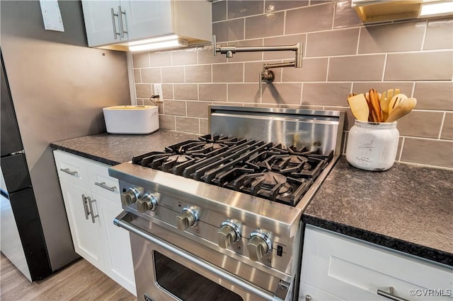 9300 Adkins Rd, Charles City, VA 23030 - kitchen with high end stainless steel range, tasteful backsplash, white cabinetry, and light wood-style floors