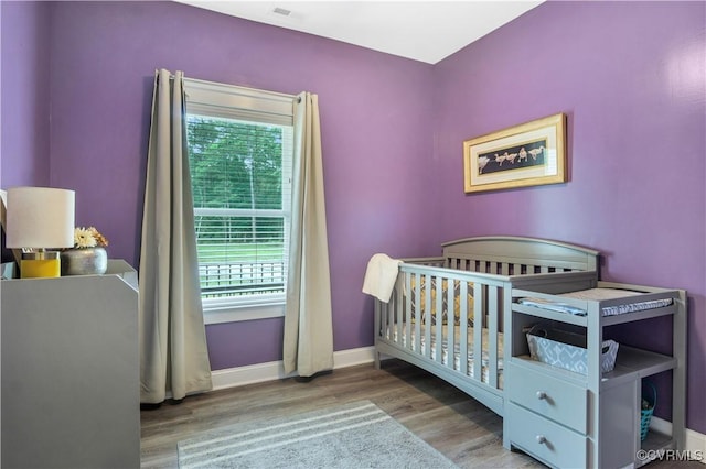 9300 Adkins Rd, Charles City, VA 23030 - bedroom featuring multiple windows, wood finished floors, a nursery area, and baseboards