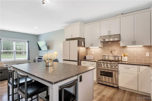 9300 Adkins Rd, Charles City, VA 23030 - kitchen featuring under cabinet range hood, freestanding refrigerator, luxury stove, dark countertops, and wine cooler