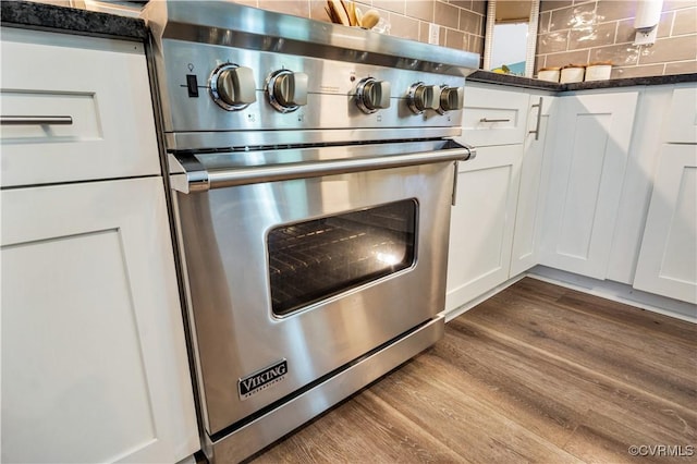 9300 Adkins Rd, Charles City, VA 23030 - kitchen view of luxury range, white cabinetry, dark wood-type flooring, tasteful backsplash, and dark stone counters
