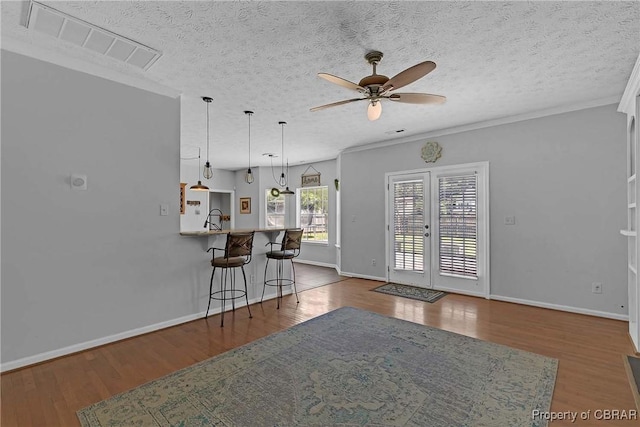 2024 Sarahs Cove Dr, Gloucester, VA 23072 - kitchen featuring ceiling fan, a breakfast bar, a textured ceiling, pendant lighting, and wood finished floors