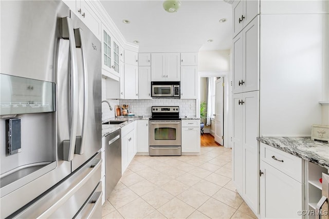 3029 Monument Ave Unit U6, Richmond, VA 23221 - kitchen featuring appliances with stainless steel finishes, a sink, tasteful backsplash, light stone countertops, and white cabinetry