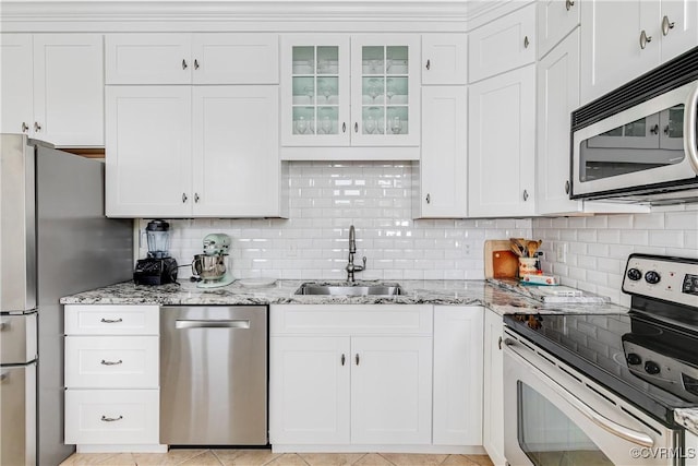 3029 Monument Ave Unit U6, Richmond, VA 23221 - kitchen with stainless steel appliances, a sink, light stone countertops, backsplash, and white cabinetry