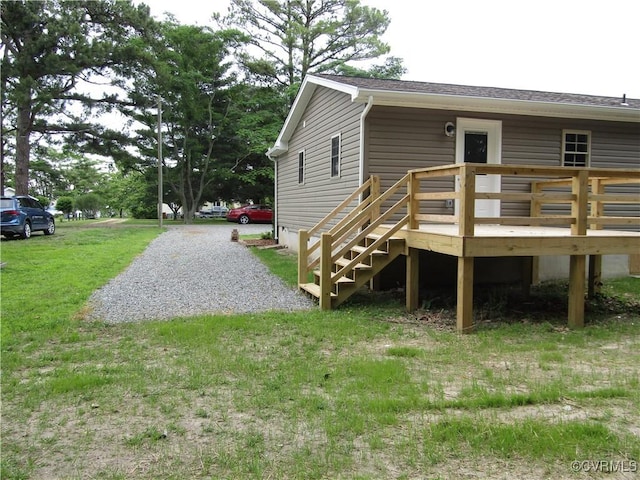 135 Trudie Dr, Center Cross, VA 22437 - rear view of property featuring a wooden deck, a lawn, and roof with shingles