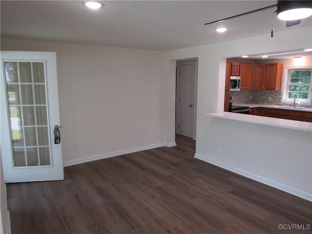 135 Trudie Dr, Center Cross, VA 22437 - kitchen with stainless steel microwave, brown cabinets, dark wood-type flooring, light countertops, and electric range