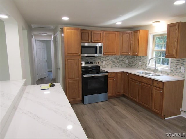 135 Trudie Dr, Center Cross, VA 22437 - kitchen featuring appliances with stainless steel finishes, wood finished floors, backsplash, brown cabinets, and recessed lighting
