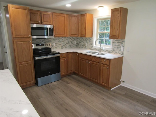 135 Trudie Dr, Center Cross, VA 22437 - kitchen with appliances with stainless steel finishes, wood finished floors, backsplash, light countertops, and recessed lighting