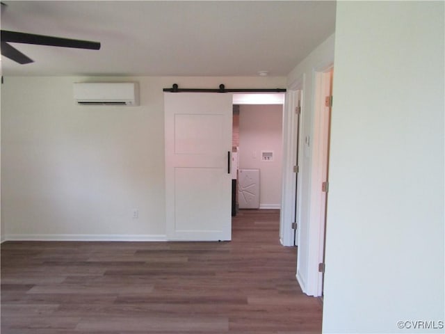 135 Trudie Dr, Center Cross, VA 22437 - spare room with a wall mounted AC, a barn door, wood finished floors, ceiling fan, and washer / dryer