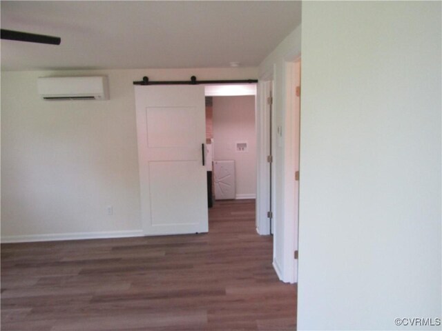 135 Trudie Dr, Center Cross, VA 22437 - empty room featuring a barn door, a wall mounted AC, and wood finished floors