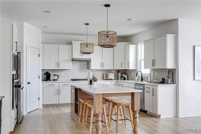 16300 Cambian Ln, Chesterfield, VA 23832 - kitchen with stainless steel dishwasher, light wood-style flooring, a kitchen island, light countertops, and white cabinetry