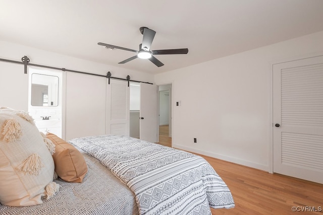 5055 Edgemere Blvd, North Chesterfield, VA 23234 - bedroom featuring a barn door, light wood finished floors, baseboards, and a ceiling fan