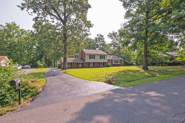 5055 Edgemere Blvd, North Chesterfield, VA 23234 - view of front of house with driveway, a front yard, a chimney, and brick siding