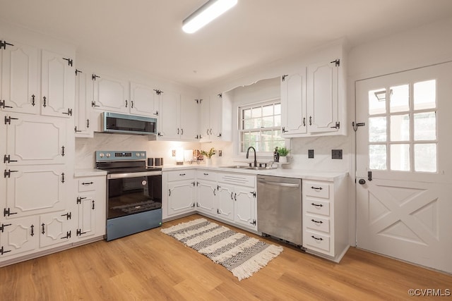 5055 Edgemere Blvd, North Chesterfield, VA 23234 - kitchen with appliances with stainless steel finishes, a sink, white cabinets, and light wood-style floors