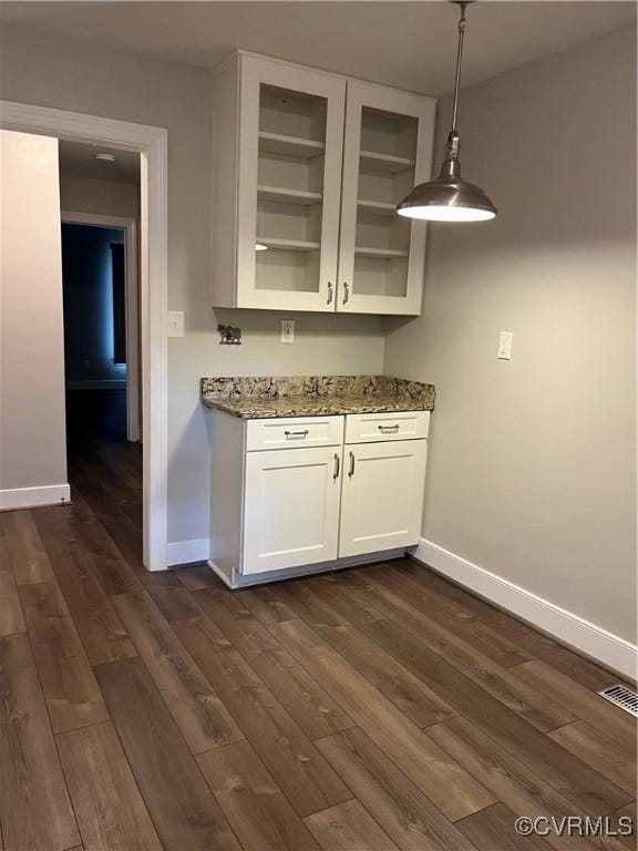 1184 Jamestown Rd Unit 19, Williamsburg, VA 23185 - kitchen featuring glass insert cabinets, light stone counters, baseboards, and dark wood-type flooring