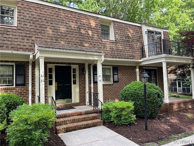 1184 Jamestown Rd Unit 19, Williamsburg, VA 23185 - doorway to property with a balcony, brick siding, roof with shingles, and mansard roof