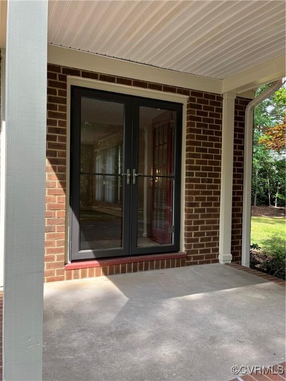 1184 Jamestown Rd Unit 19, Williamsburg, VA 23185 - view of exterior entry featuring brick siding, french doors, and a patio area