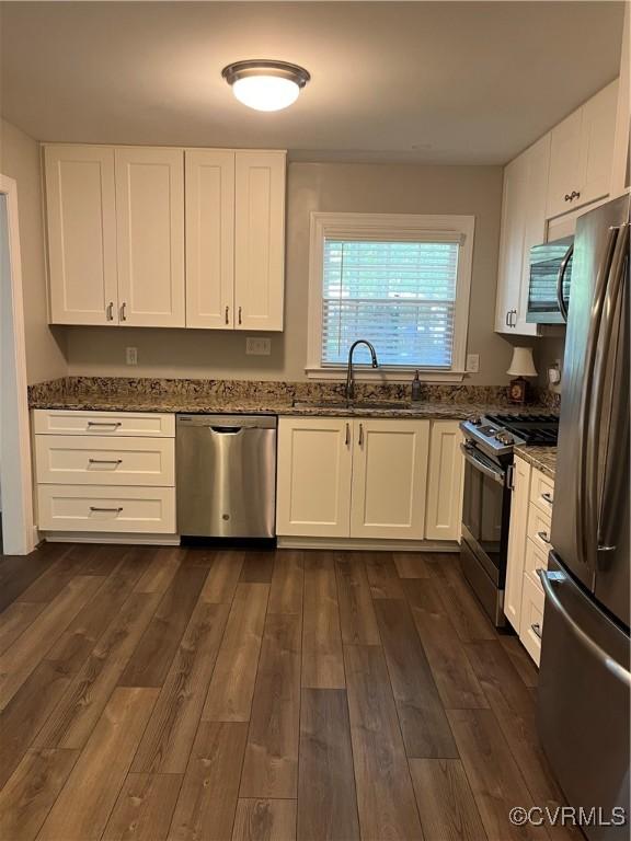 1184 Jamestown Rd Unit 19, Williamsburg, VA 23185 - kitchen featuring appliances with stainless steel finishes, a sink, dark stone counters, and white cabinetry