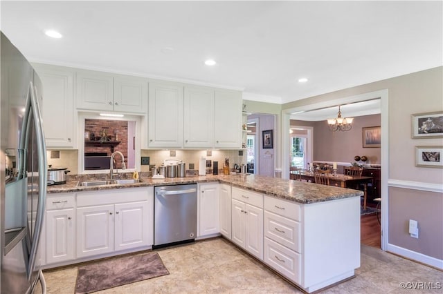 1468 Peppercorn Ln, Suffolk, VA 23432 - kitchen featuring stainless steel appliances, a sink, a peninsula, white cabinets, and a chandelier