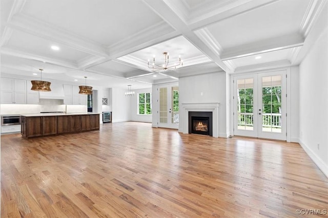 343 Petersburg Rd, Powhatan, VA 23139 - unfurnished living room with a chandelier, light wood-type flooring, a warm lit fireplace, beamed ceiling, and coffered ceiling