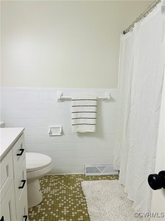 225 Philray Rd, Chesterfield, VA 23236 - full bathroom with vanity, toilet, a wainscoted wall, tile walls, and tile patterned floors