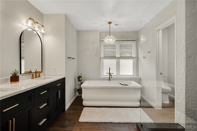 7727 Centerbrook Ct, Chesterfield, VA 23832 - full bath with double vanity, a soaking tub, wood finished floors, a chandelier, and baseboards