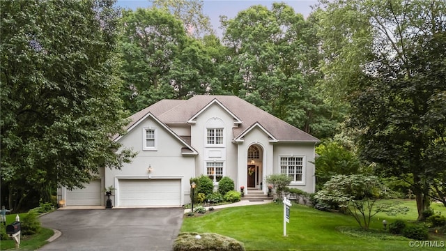 5225 Clipper Cove Rd, Chesterfield, VA 23112 - traditional-style house featuring stucco siding, asphalt driveway, a front lawn, roof with shingles, and a garage