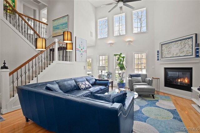 5225 Clipper Cove Rd, Chesterfield, VA 23112 - living room featuring a high ceiling, wood finished floors, stairs, a ceiling fan, and a glass covered fireplace