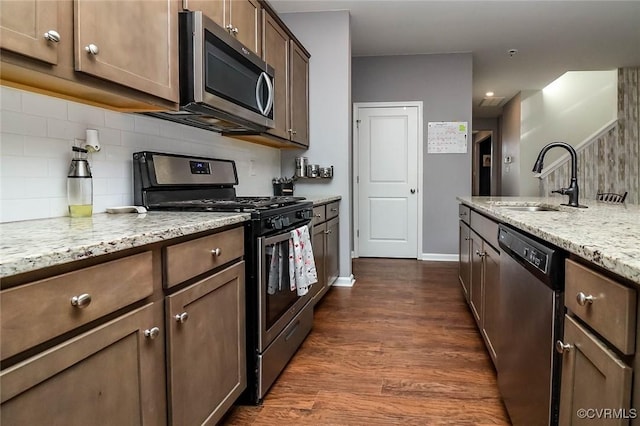 7547 Sedge Dr, New Kent, VA 23124 - kitchen featuring stainless steel appliances, decorative backsplash, dark wood-style flooring, and light stone counters