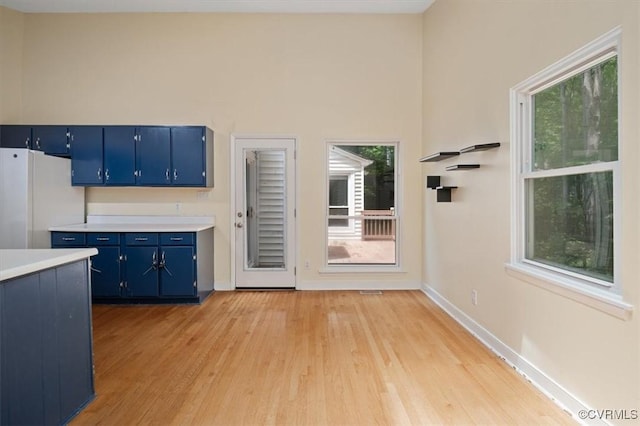 3201 Barnes Spring Ct, Chesterfield, VA 23112 - kitchen featuring blue cabinets, freestanding refrigerator, light countertops, and light wood finished floors