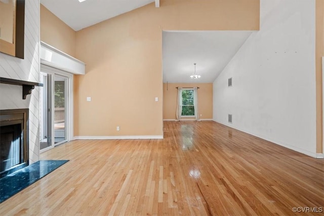 3201 Barnes Spring Ct, Chesterfield, VA 23112 - unfurnished living room with a premium fireplace, light wood-style flooring, high vaulted ceiling, baseboards, and a chandelier