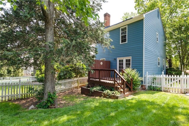 2619 Quarterpath Pl, Henrico, VA 23233 - rear view of property featuring a chimney, a fenced backyard, a wooden deck, and a vegetable garden