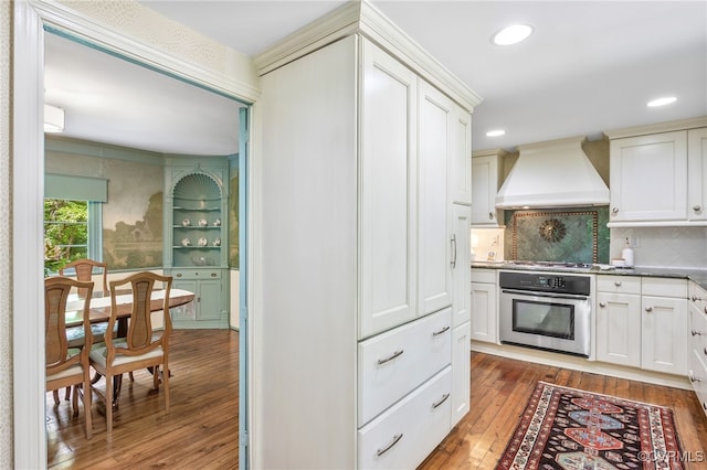 4103 Beechmont Rd, Richmond, VA 23235 - kitchen with oven, custom exhaust hood, light wood-style flooring, decorative backsplash, and recessed lighting