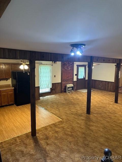 733 Holland Point Rd, Dutton, VA 23050 - unfurnished living room featuring wooden walls, light colored carpet, and heating unit