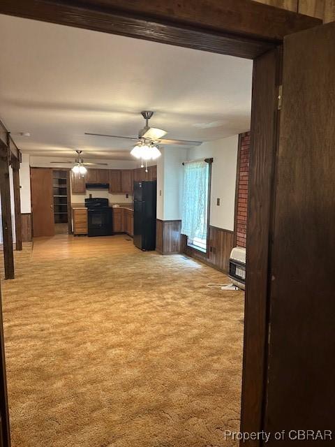 733 Holland Point Rd, Dutton, VA 23050 - unfurnished living room featuring light colored carpet, wainscoting, a ceiling fan, heating unit, and wooden walls