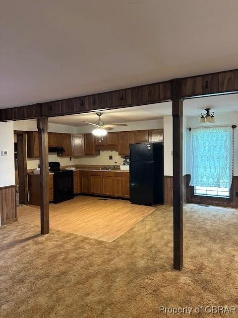 733 Holland Point Rd, Dutton, VA 23050 - kitchen with black appliances, light carpet, wooden walls, ceiling fan, and light countertops