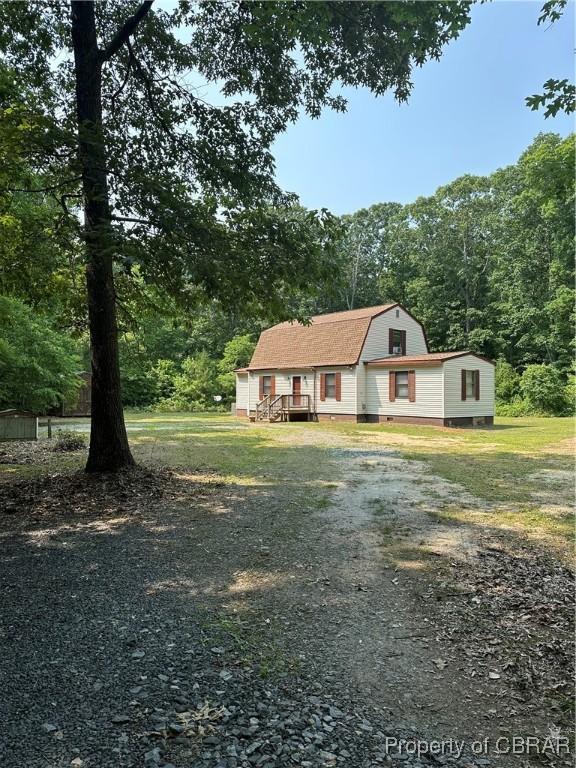 733 Holland Point Rd, Dutton, VA 23050 - view of front of home featuring a gambrel roof, driveway, and a view of trees