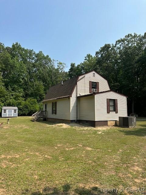 733 Holland Point Rd, Dutton, VA 23050 - view of home's exterior featuring a lawn, cooling unit, a gambrel roof, and view of scattered trees
