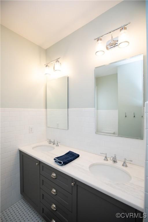 908 High St, Farmville, VA 23901 - bathroom with double vanity, tile walls, and a wainscoted wall