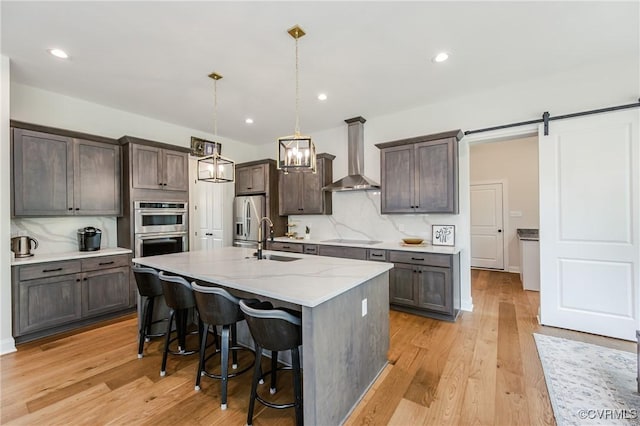 4507 Summer Camp Ct, Moseley, VA 23120 - kitchen featuring wall chimney exhaust hood, appliances with stainless steel finishes, a sink, backsplash, and a breakfast bar