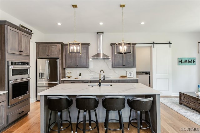 4507 Summer Camp Ct, Moseley, VA 23120 - kitchen with appliances with stainless steel finishes, wall chimney exhaust hood, a sink, light stone countertops, and recessed lighting